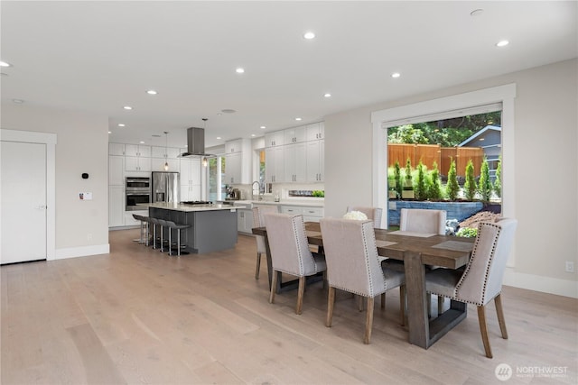 dining space featuring light wood-style floors, recessed lighting, and baseboards