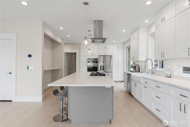 kitchen with stainless steel appliances, island range hood, a sink, tasteful backsplash, and recessed lighting
