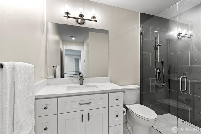 bathroom featuring a stall shower, toilet, and vanity