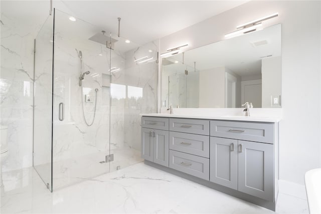bathroom featuring a marble finish shower, marble tiled floors, double vanity, and toilet