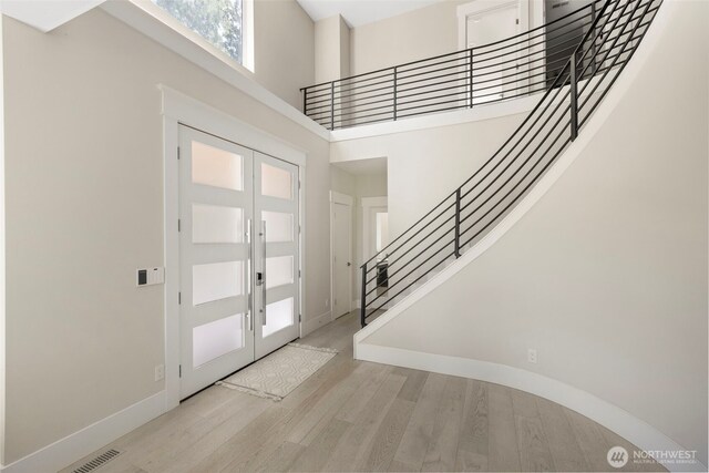 16831 84th Ln NE, Kenmore, WA 98028 - foyer entrance with a high ceiling, stairs, light wood finished floors, baseboards, and french doors