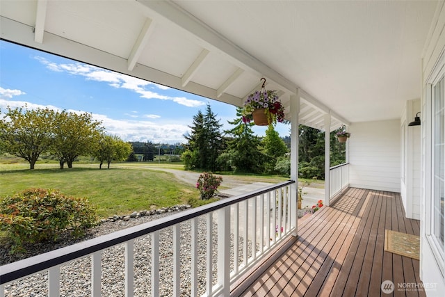 wooden terrace with a porch and a yard