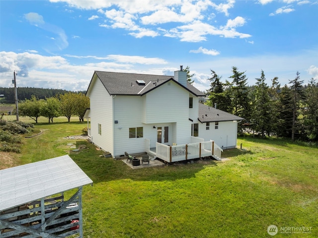 back of property with a chimney, a yard, a deck, and a shingled roof