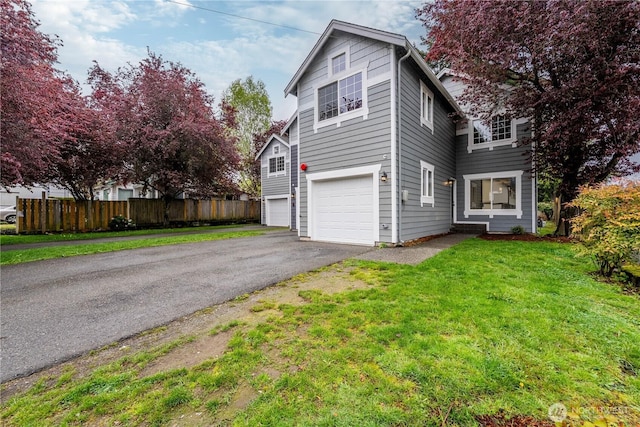 view of front of property with a garage, fence, driveway, and a front yard