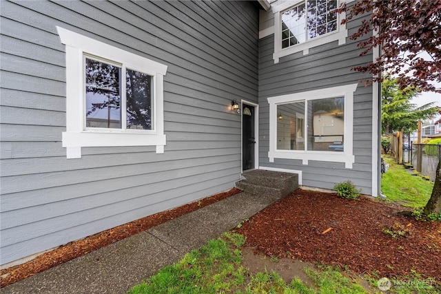 view of exterior entry featuring fence