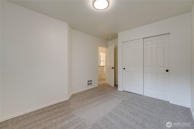 unfurnished bedroom featuring visible vents, carpet, baseboards, and a closet