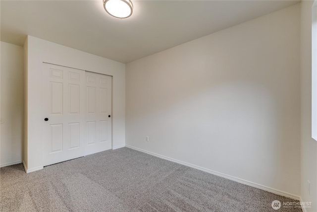 unfurnished bedroom featuring carpet floors, baseboards, and a closet
