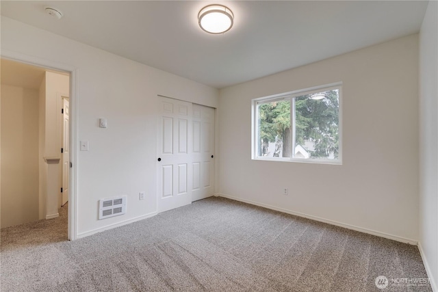 unfurnished bedroom with visible vents, carpet flooring, baseboards, and a closet