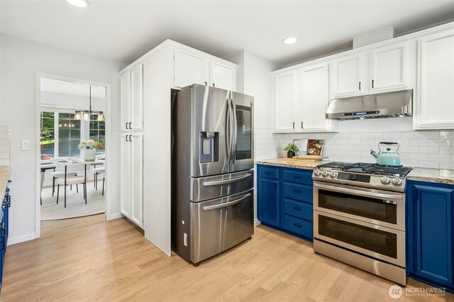 kitchen with white cabinets, appliances with stainless steel finishes, light wood-type flooring, under cabinet range hood, and blue cabinets