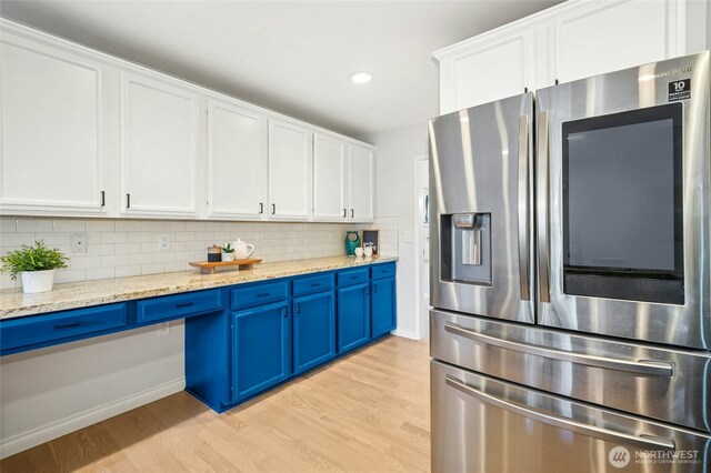 kitchen featuring white cabinetry, light wood-type flooring, stainless steel fridge with ice dispenser, and blue cabinets