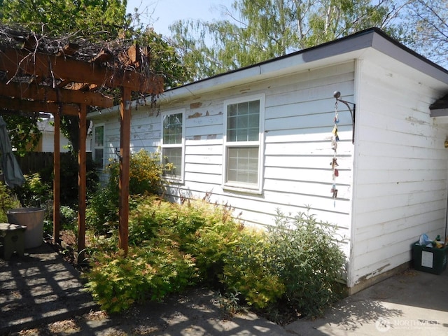 view of home's exterior featuring fence and a pergola