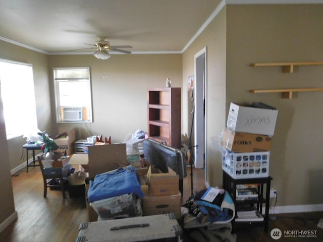 interior space with ceiling fan, cooling unit, baseboards, wood finished floors, and ornamental molding