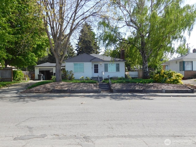 view of front of property featuring a chimney and concrete driveway