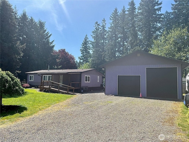 view of front of home with a garage, an outbuilding, a front lawn, and driveway