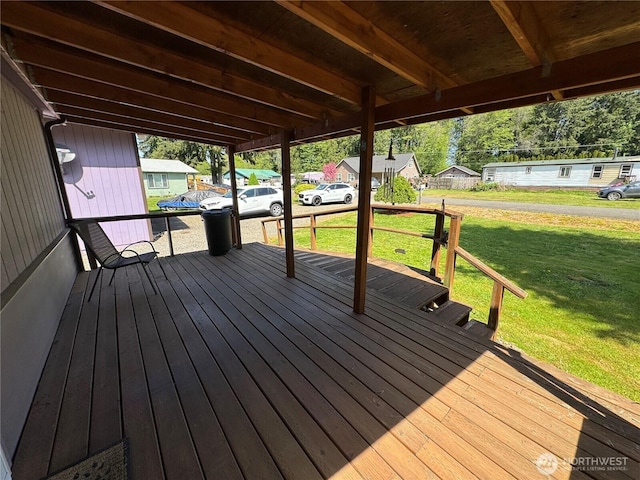 wooden terrace featuring a lawn