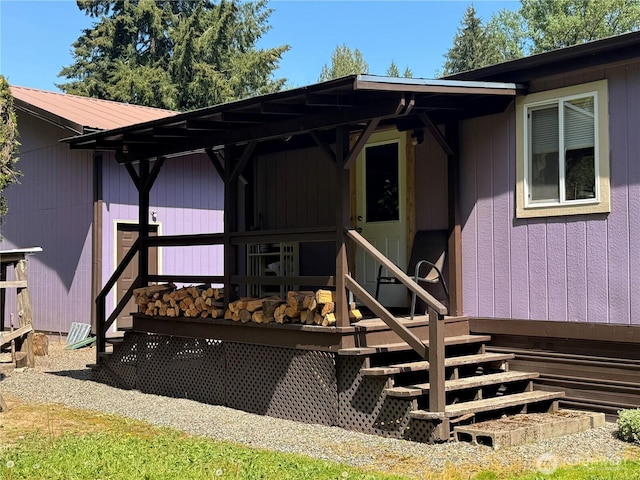 view of exterior entry featuring a wooden deck and metal roof