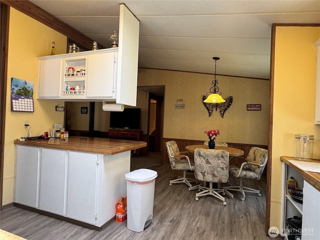 kitchen featuring butcher block countertops, wood finished floors, and white cabinets