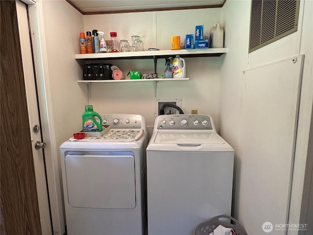 clothes washing area featuring crown molding, laundry area, visible vents, and washer and clothes dryer