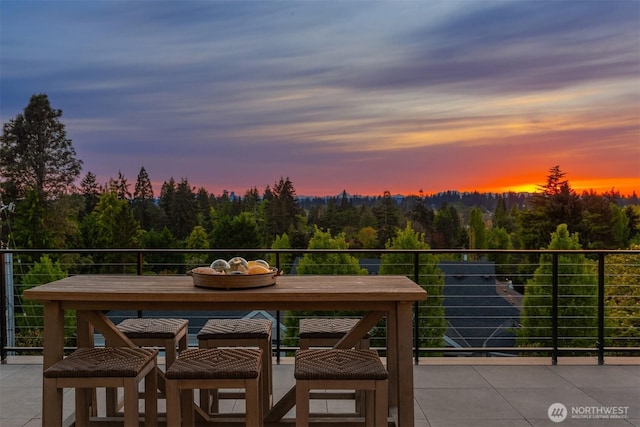 1032 89th Ave NE, Bellevue, WA 98004 - balcony at dusk featuring outdoor dining area and a forest view