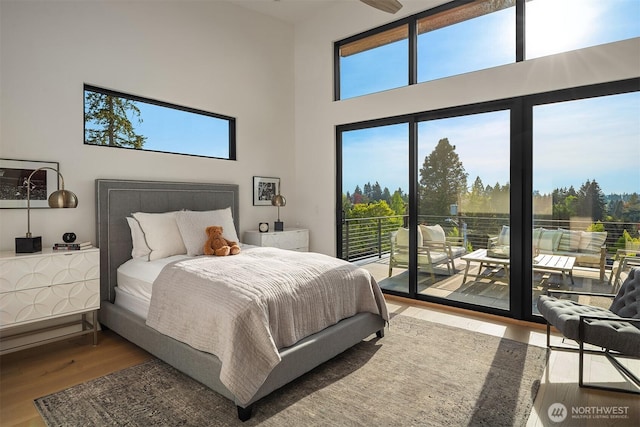 1032 89th Ave NE, Bellevue, WA 98004 - bedroom with access to exterior, wood finished floors, multiple windows, and a towering ceiling