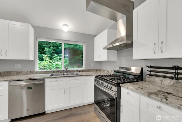 kitchen with stainless steel appliances, a sink, white cabinets, and light wood finished floors