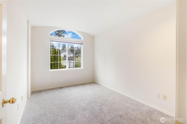 carpeted empty room featuring baseboards and visible vents