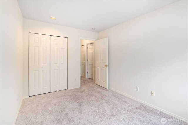 unfurnished bedroom with baseboards, carpet flooring, recessed lighting, and a closet