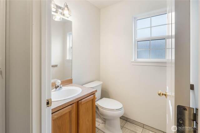 half bathroom featuring vanity, tile patterned floors, and toilet