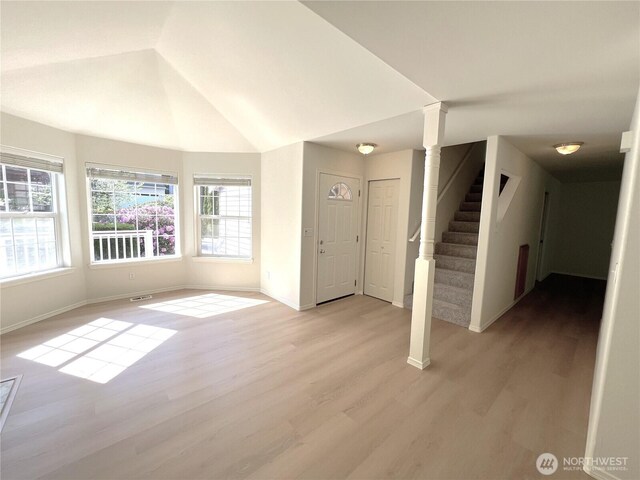interior space with light wood-style flooring, stairs, baseboards, ornate columns, and visible vents