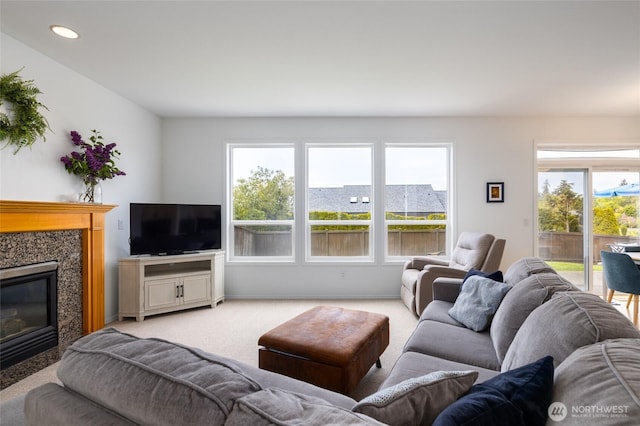 living area with plenty of natural light, light carpet, recessed lighting, and a premium fireplace
