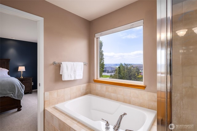 ensuite bathroom with connected bathroom and a bath