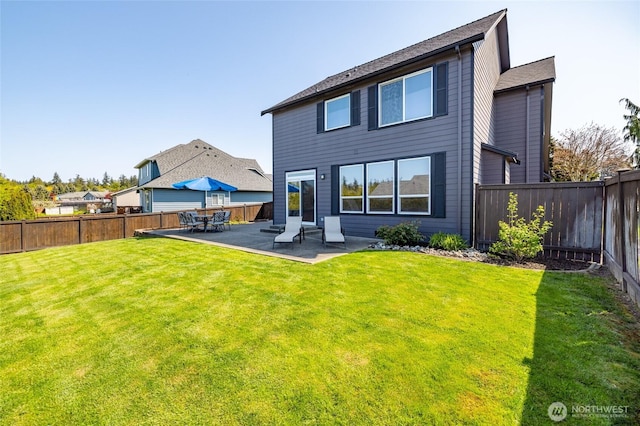rear view of property with a lawn, a fenced backyard, and a patio