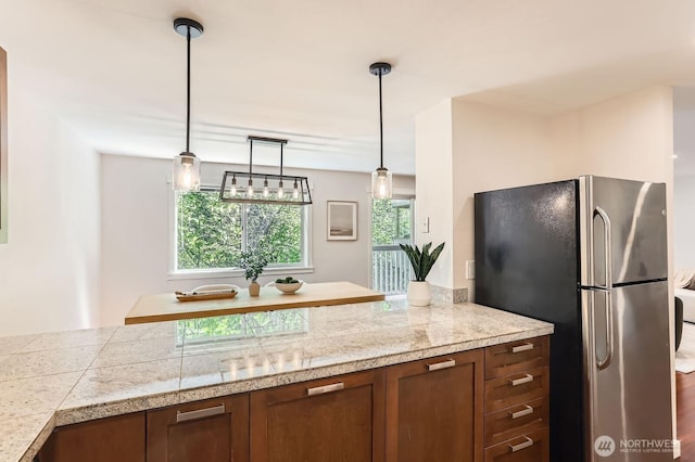 3018 128th Ave SE Unit 10, Bellevue, WA 98005 - kitchen featuring tile counters, freestanding refrigerator, brown cabinets, and decorative light fixtures