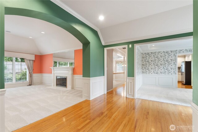 4799 171st Ave SE, Bellevue, WA 98006 - unfurnished living room with crown molding, wainscoting, a decorative wall, lofted ceiling, and light wood-type flooring