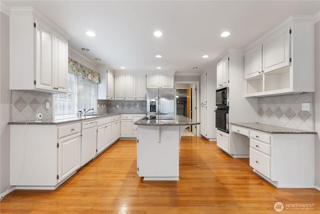 4799 171st Ave SE, Bellevue, WA 98006 - kitchen with a center island, decorative backsplash, black appliances, and light wood-type flooring