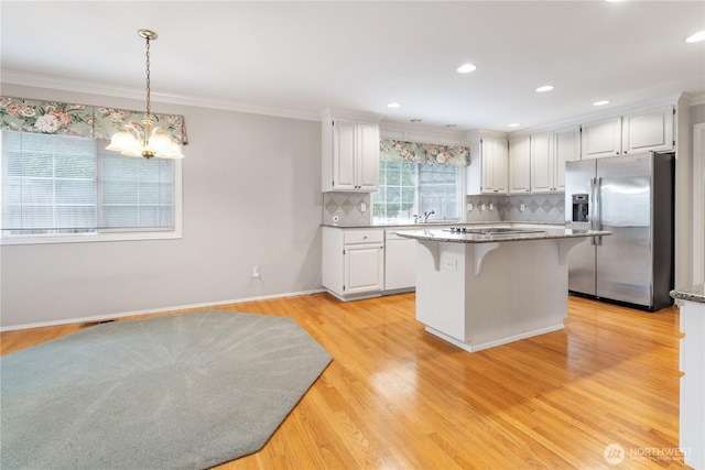 4799 171st Ave SE, Bellevue, WA 98006 - kitchen with white cabinets, stainless steel refrigerator with ice dispenser, ornamental molding, and a breakfast bar area
