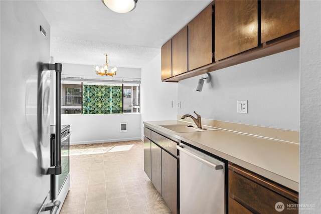 1346 Orleans, Bellingham, WA 98229 - kitchen with appliances with stainless steel finishes, a sink, a chandelier, light tile patterned floors, and light countertops