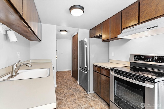 1346 Orleans, Bellingham, WA 98229 - kitchen with stainless steel appliances, under cabinet range hood, a sink, light countertops, and dark brown cabinetry