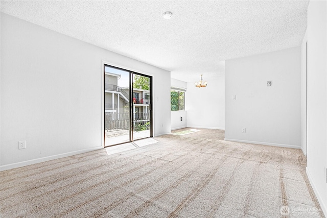 1346 Orleans, Bellingham, WA 98229 - empty room featuring a chandelier, a textured ceiling, carpet floors, and baseboards