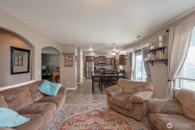 living area featuring arched walkways and baseboards