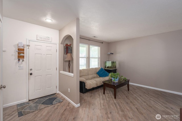 entryway featuring baseboards, visible vents, and wood finished floors