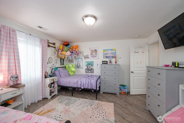 bedroom featuring visible vents and wood finished floors