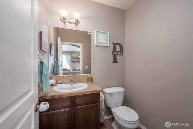 bathroom with vanity, baseboards, and toilet