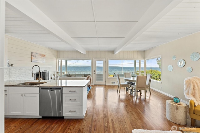 kitchen with a sink, baseboards, beamed ceiling, dark wood-style floors, and a water view