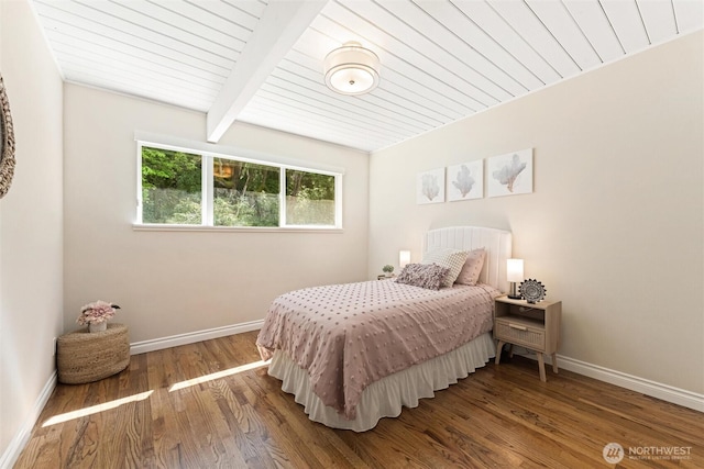 bedroom with baseboards, beamed ceiling, wood ceiling, and wood finished floors