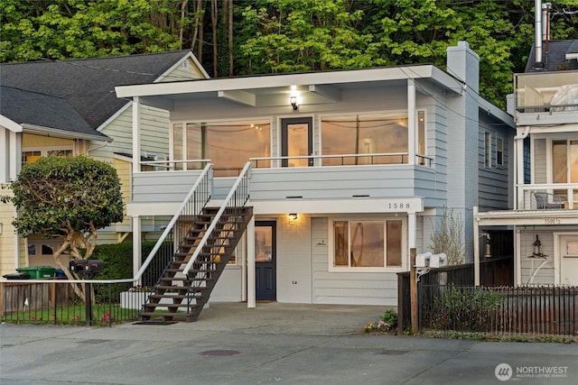 view of front of home featuring stairway and fence
