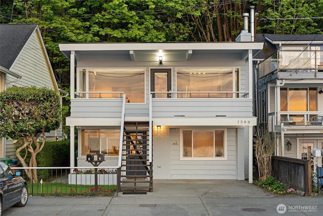 townhome / multi-family property featuring fence and stairway