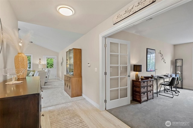 interior space with baseboards and vaulted ceiling