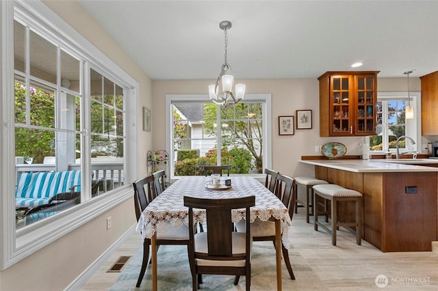 dining space featuring a notable chandelier, visible vents, and baseboards