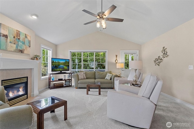 living area with carpet flooring, a fireplace, a ceiling fan, baseboards, and vaulted ceiling